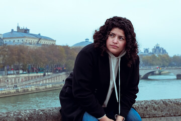 Mujer latina sonriendo sentada por las calles de Paris