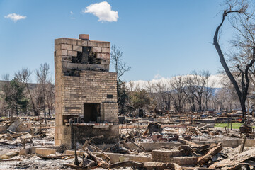 Aftermath of wildfire damage in residential neighborhood with complete destruction of property.
