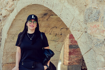 Mujer latina sonriente abajo de un puente