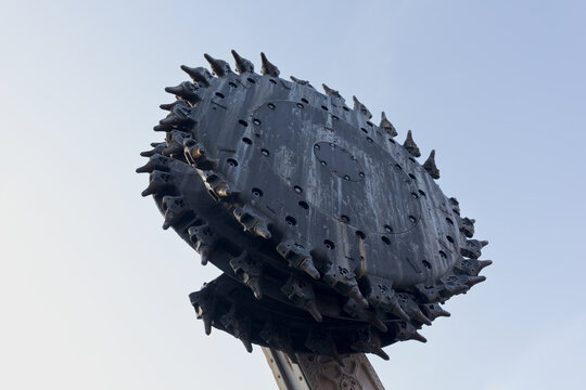 Wheel rotary excavator, digger and driller - industrial machine for digging, drilling and tunneling in underground coal mine. Blue sky as copy space.
