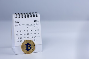 May 2025 calendar and bitcoin coin on white bacground