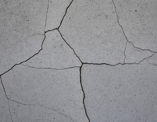 Obraz premium Detailed close-up of cracked concrete, showcasing natural wear and structural imperfections. This image is perfect for use in industrial themes, construction-related projects, weathered textures, or a