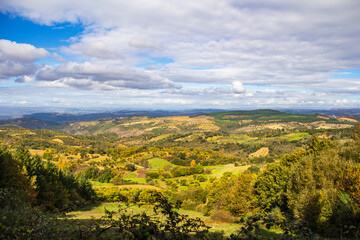 Vista da montanha para os vales verdes sob um c&eacute;u azul com algumas nuvens brancas