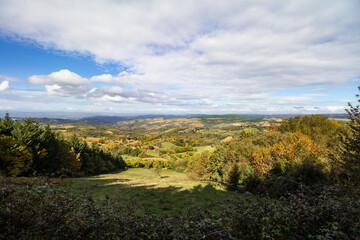 Vista da montanha para os vales verdes sob um c&eacute;u azul com algumas nuvens brancas