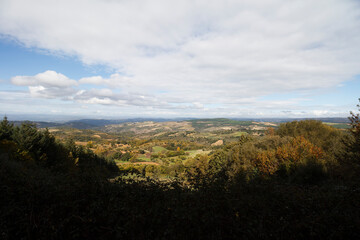 Vista da montanha para os vales verdes sob um c&eacute;u azul com algumas nuvens brancas