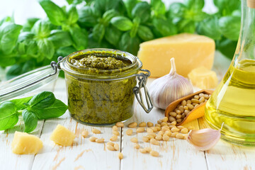 Close up of jar of homemade basil pesto with pine nuts ,garlic , olive oil, parmesan and green...