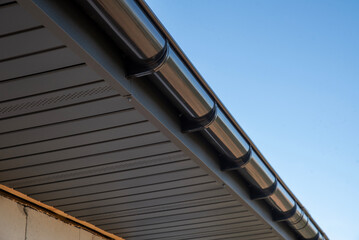 A house with a new rain gutter and a gray soffit