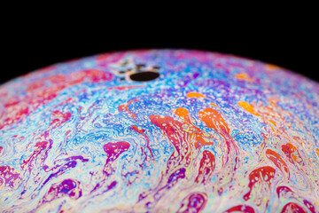 Multicolored abstract chaotic pattern inside of the soap bubble, closeup