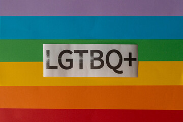 Rainbow flag background with the LGTBI+ word