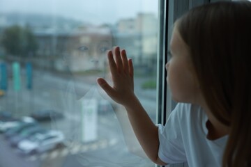 Fototapeta premium Autism concept. Lonely little girl near window at home, space for text