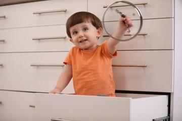 Little boy playing with kitchen appliances indoors. Dangerous situation