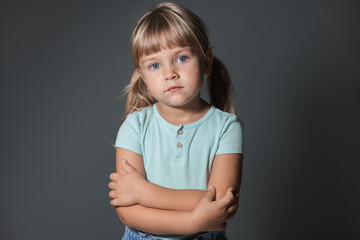 Orphanage concept. Sad little girl on grey background