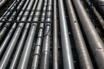 A detailed view of industrial pipelines at an energy or chemical plant in Sines, Portugal, showcasing the metallic texture and alignment of multiple large pipes used for transport.
