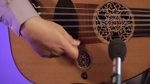 Panning right across musician playing oud instrument middle eastern music performance