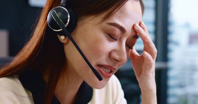 Frustrated, asian woman and consultant with mic at call center for difficult customer or error at office. Japanese, female person or face of agent with headset or stress for online issue or advice