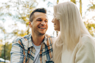 Fototapeta premium Positive middle aged couple in love talking each other, sitting outdoors on the street, talking