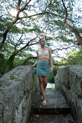 Obraz premium Young woman walking on stone bridge in havana forest