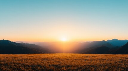 Obraz premium A beautiful, sunlit field with mountains in the background