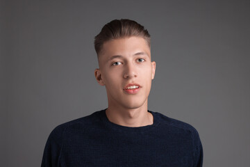 Fototapeta premium Handsome young man with stylish haircut on grey background