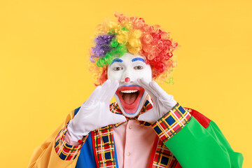 Portrait of clown screaming on yellow background