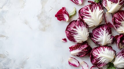 Bright radicchio leaves are artfully spread on a white background, highlighting their color