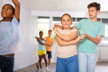 Fototapeta premium Joyful girl and boy practicing dance in pairs in wellness center