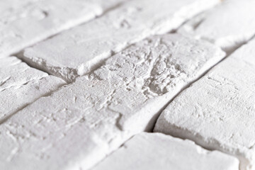 A detailed close-up of a white brick wall showcasing texture and depth, ideal for backgrounds in...