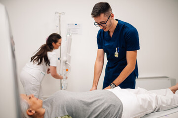 Obraz premium Medical professionals facilitate a CT scan examination of a patient.