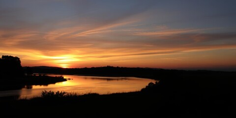 Obraz premium Silhouette of photographer capturing sunset by river, hobby, evening