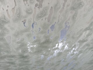 water drops on the window. At the car wash. Foam on the car window during washing. A clean car