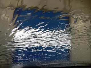 At the car wash. Water flows on the car window during washing. A clean car