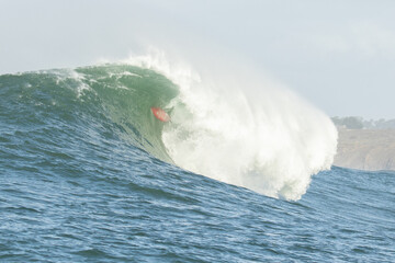 Surfer stuck inside the tube of a monster wave at Mavericks's big wave destination. Can be used to...