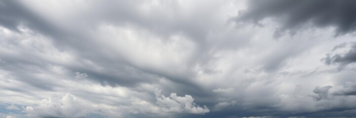 Fototapeta premium Dramatic clouds covering the sky in shades of gray and white, natural, ominous