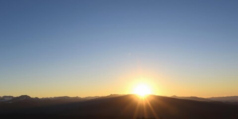 Obraz premium A stunning image of the sun rising against a backdrop of majestic mountains, casting a beautiful golden glow over the landscape, shadow, majestic