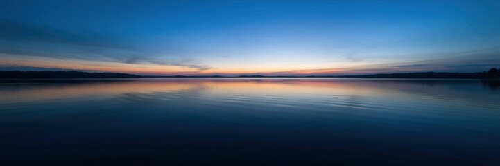 A tranquil image of a serene lake at dusk, with the water reflecting the soft hues of the setting sun, reflection, peaceful