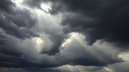 Fototapeta premium Ominous dark storm clouds with rays of sunlight breaking through, dramatic lighting, sunlight