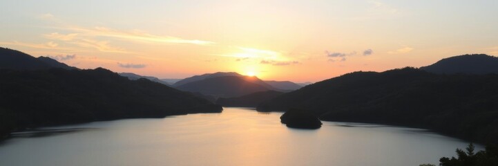 Fototapeta premium A stunning sunset over a tranquil lake surrounded by lush green hills and forests, nature, beauty