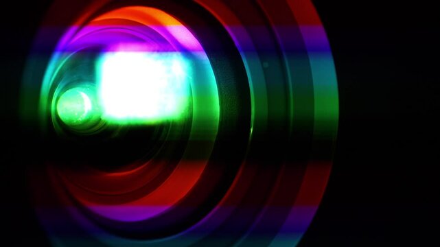 Spectral decomposition of light. Projector lens in operation, close-up shot video. Dispersion - decomposition of light into spectral colors