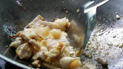 Slow motion footage of frying beef, pork for cooking in the kitchen. Home cooking. Stir frying beef, cooking with heat from a gas stove.