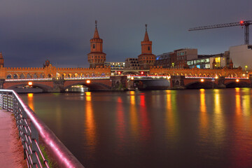 Obraz premium View of the old historic stone Oberbaum bridge over the Spree river in Berlin at sunset. Germany.