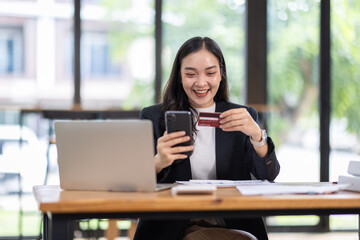 Fototapeta premium woman use laptop with online shopping digital cart with credit card for shopping payment online with application.Intelligent Ecommerce,internet banking payment,financial technology. lifestyle.