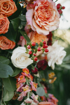 Intricate wedding arch featuring blush and red roses, white blooms, and vibrant snapdragons. A perfect example of elegant floral design for a backyard wedding in Savannah, Georgia