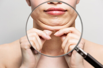 ルーペで女性の二重顎を拡大している.