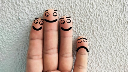 Four fingers are decorated as four person. Three of them is bullying an old man. Racial...