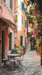 Obraz premium Charming Italian Alleyway: A picturesque scene of a cobblestone alleyway in Italy, lined with charming terracotta buildings, vibrant greenery, and a quaint cafe table set for two.