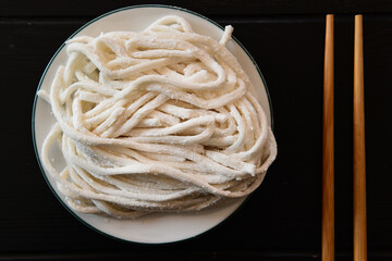 Close up of fresh udon noodles on white plate 
