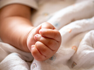 Newborn baby hand clenching family home close-up photo cozy environment intimate viewpoint joy of parenthood