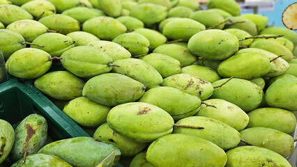 Close-up Fresh Green Mangoes: A vibrant display of green mangoes, piled high, evokes a sense of abundance and tropical freshness.	