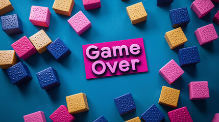 A vibrant game over sign is surrounded by colorful textured cubes arranged on a bright blue background.