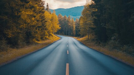 Naklejka premium Winding road through autumn forest with colorful trees